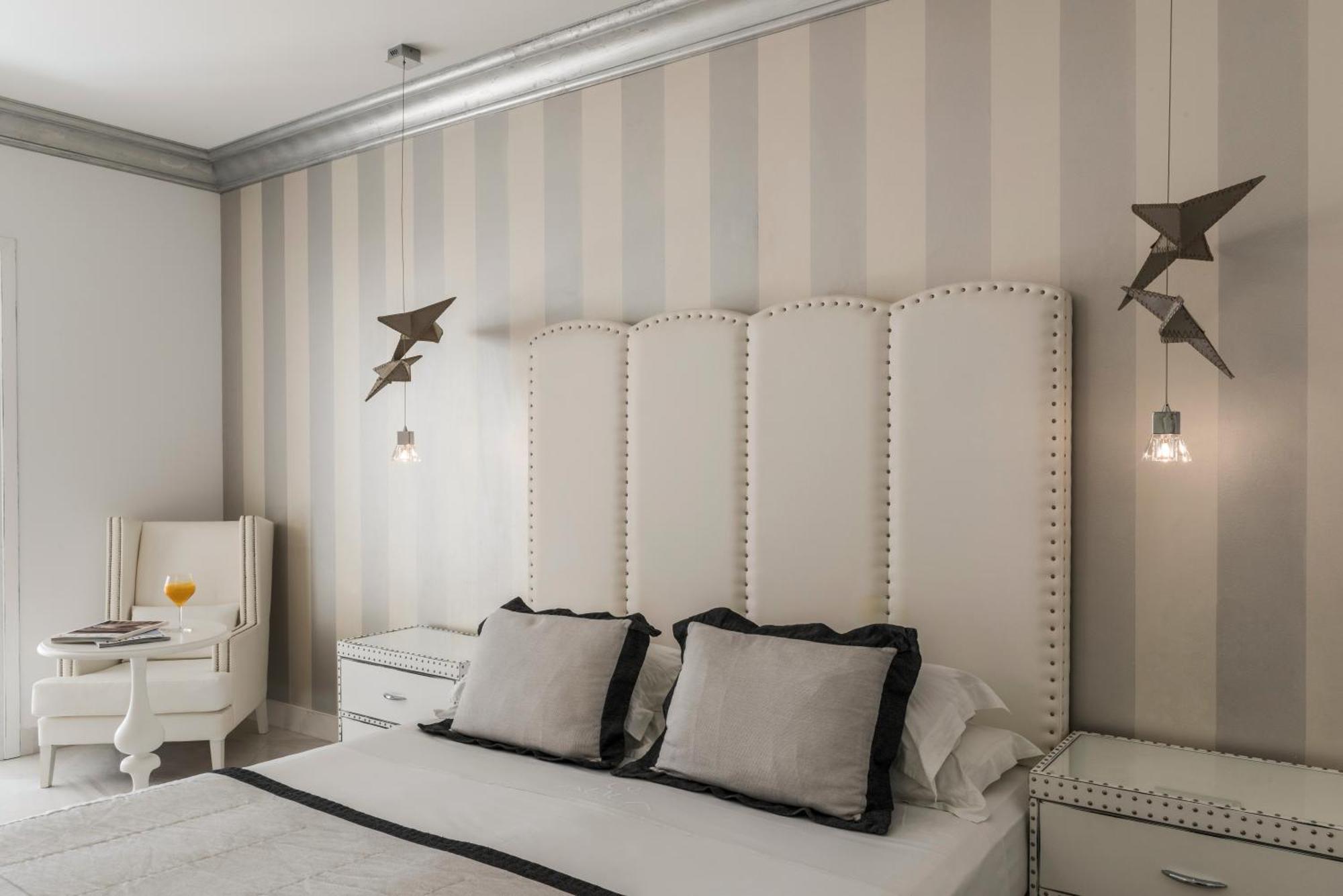 Mitsis Selection Alila Hotel Faliraki Cameră foto A bedroom with a bed, a nightstand, a chair, and a lamp