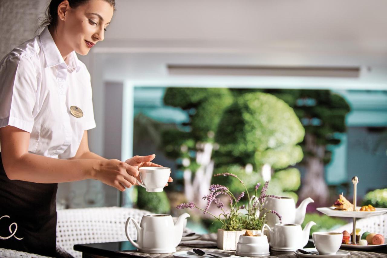 Mitsis Selection Alila Hotel Faliraki Exterior foto A flight attendant serving tea on board a plane